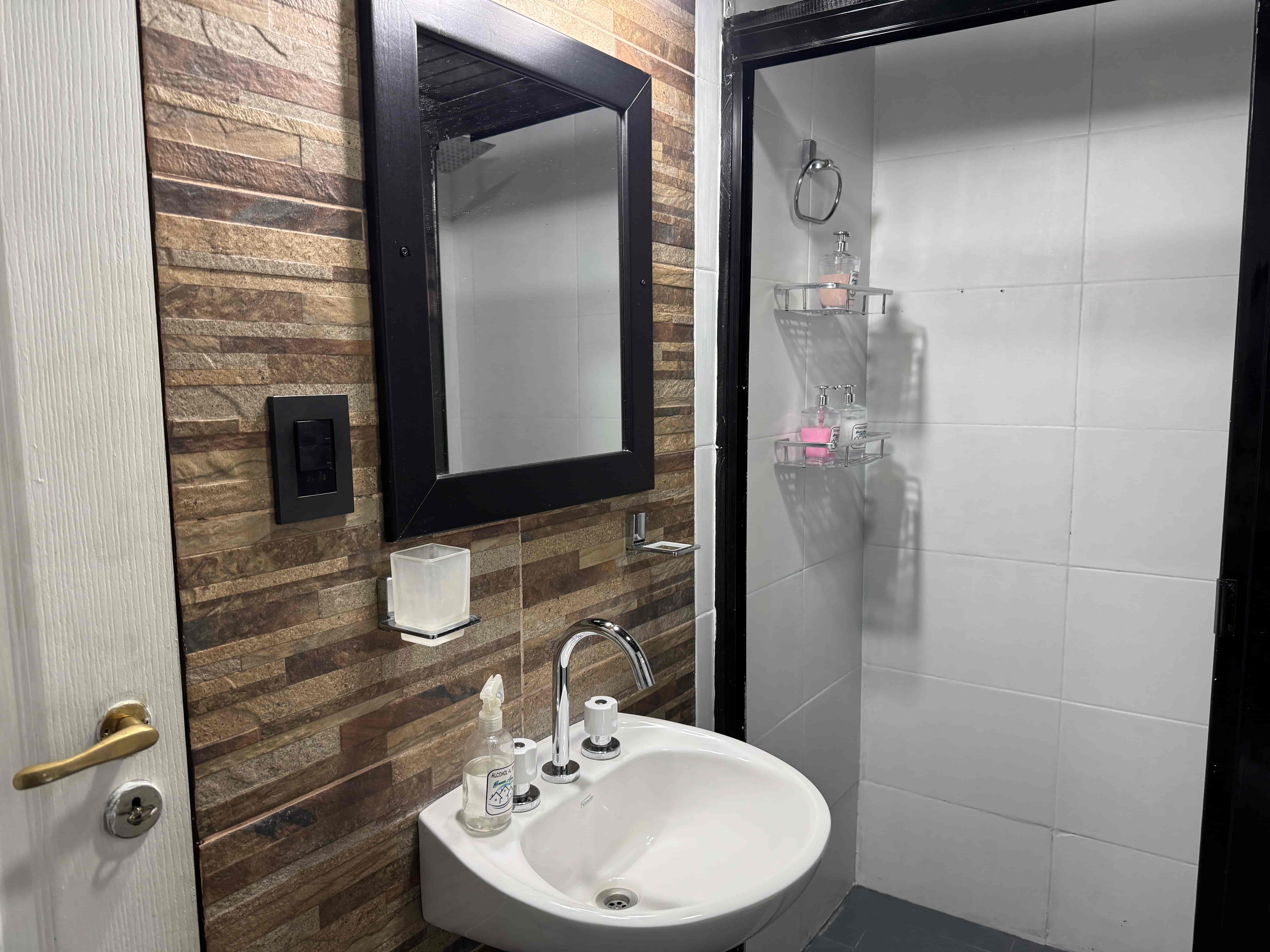 Baño con revestimiento símil piedra y bacha